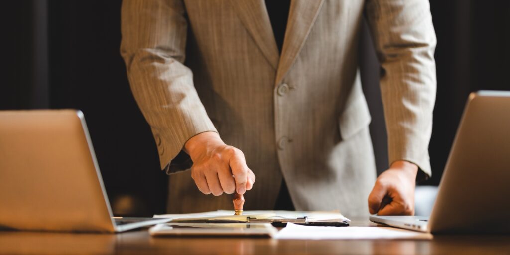 hand stamping with approved stamp on certificate document public paper at desk, notary or business